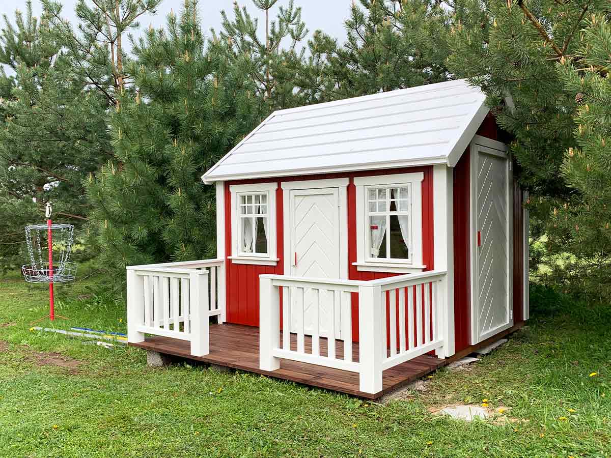 Nordic Nario playhouse with red wooden walls, white steel roof and white terrace railings by KidsPlayHouses_EU