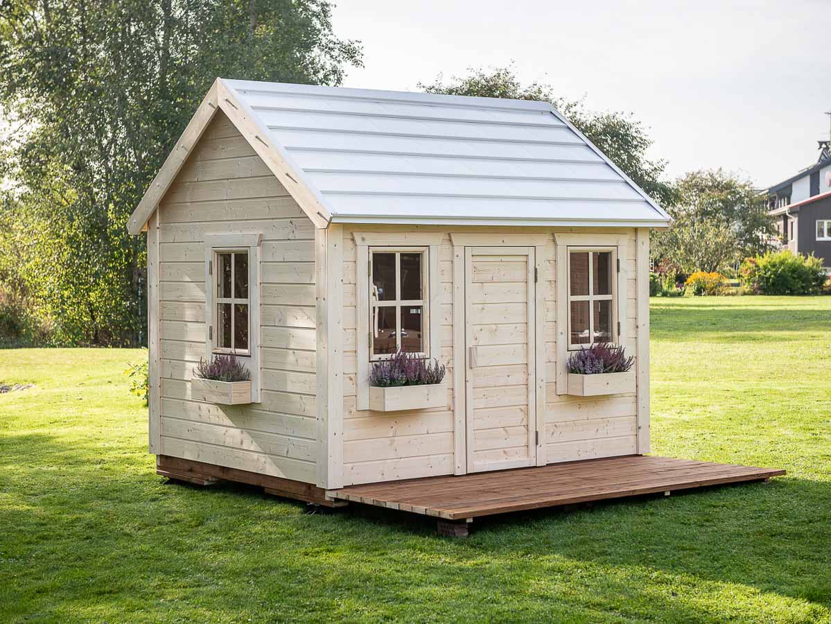 In the garden is the beautiful KidsPlayHouses_EU kids playhouse Natural, which quickly assembles.