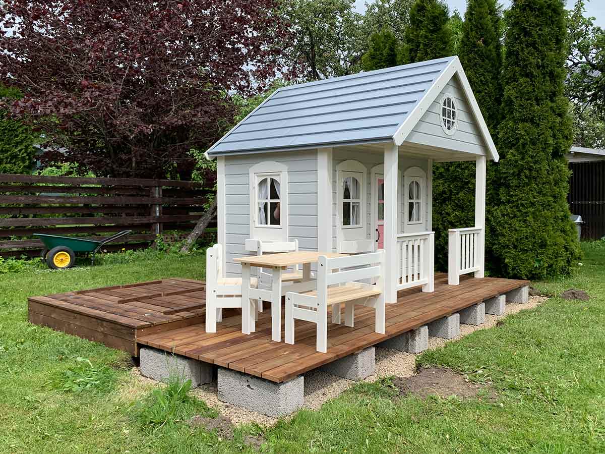 KidsPlayHouses_EU exterior light grey playhouse with black steel roof, sandbox, terrace and kids furniture.