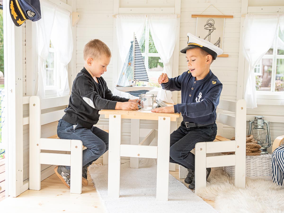 Boys play in KidsPlayHouses_EU inside a painted playhouse on wooden kids furniture