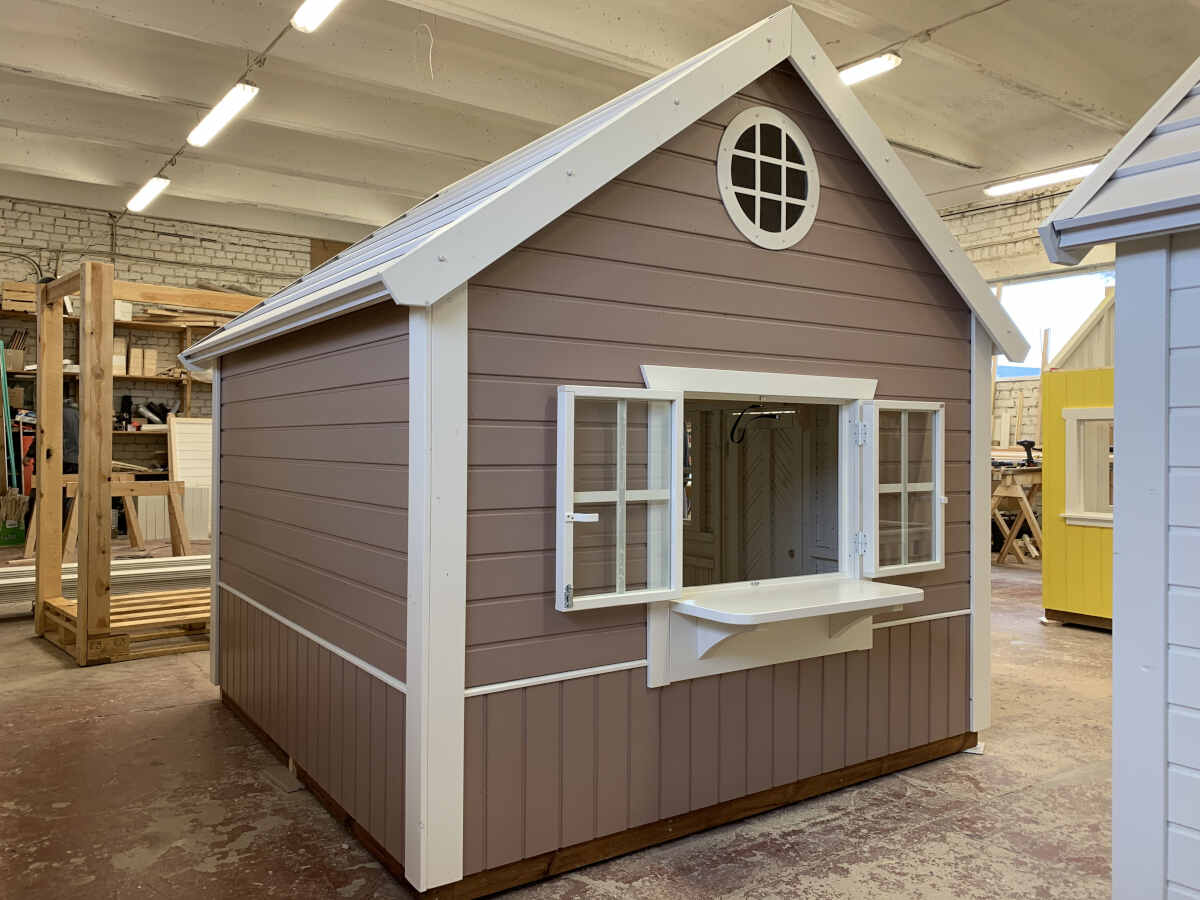 Playhouse with brown siding and white trim in a showroom setting with Play Store Window and Counter