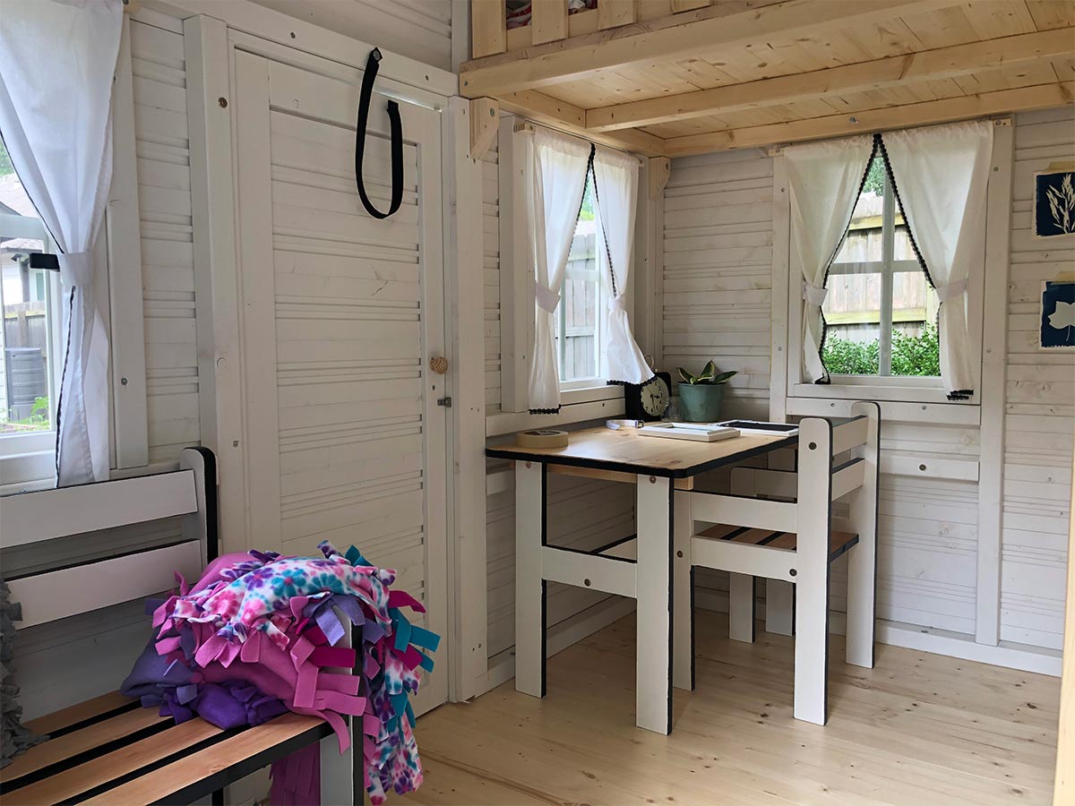 KidsPlayHouses_EU White playhouse Snowy Owl interior with kids furniture: table, two chairs and bench