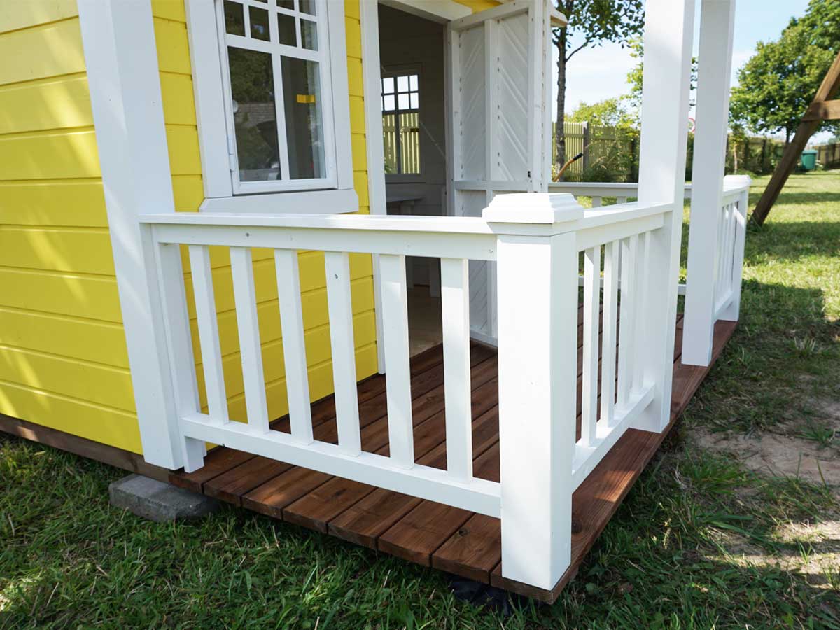 KidsPlayHouses_EU solid wood yellow playhouse Sunny Sadie with white railing