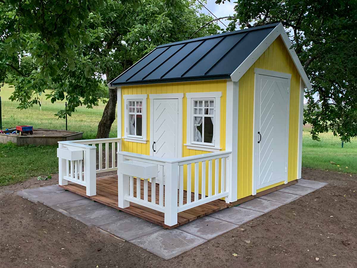 KidsPlayHouses_EU yellow playhouse Sunshine with black roof, white herringbone door and wooden terrace